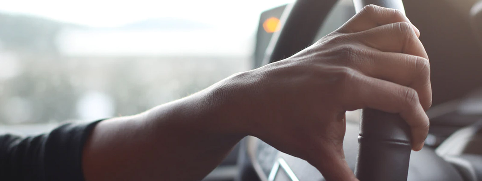 Close up view of hand on steering wheel | Auto Insurance