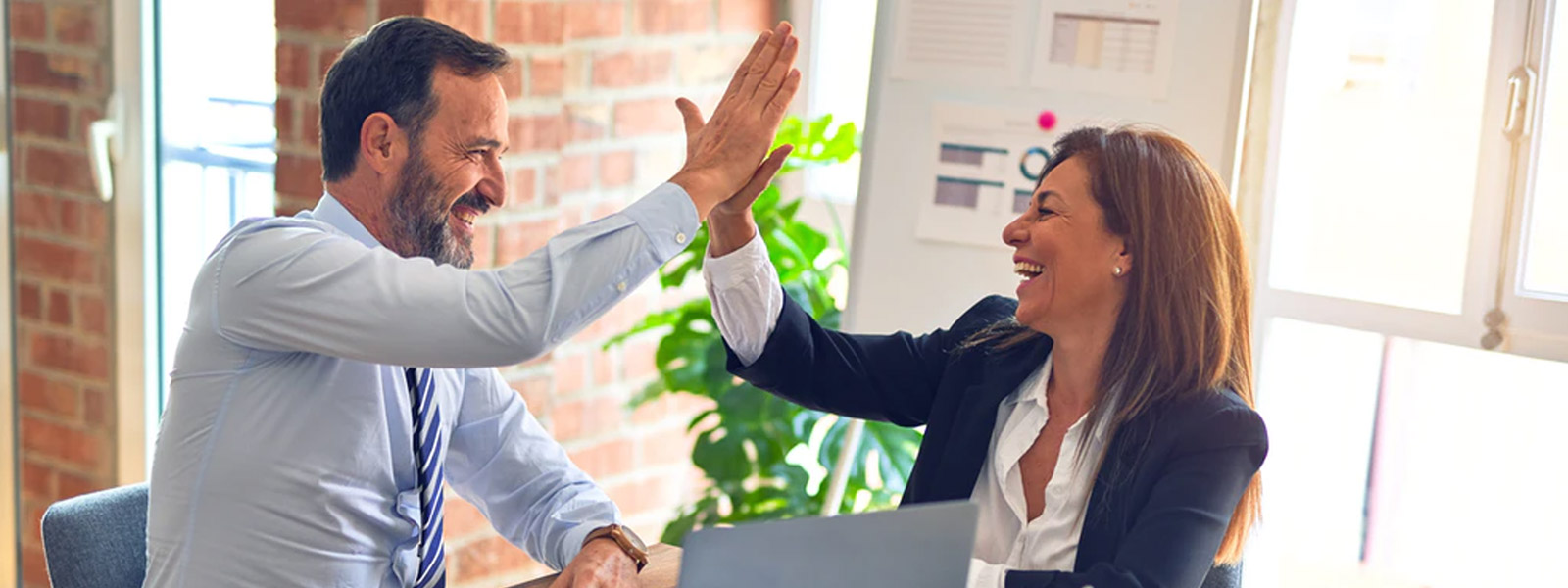 Man and woman giving high five | Business Insurance